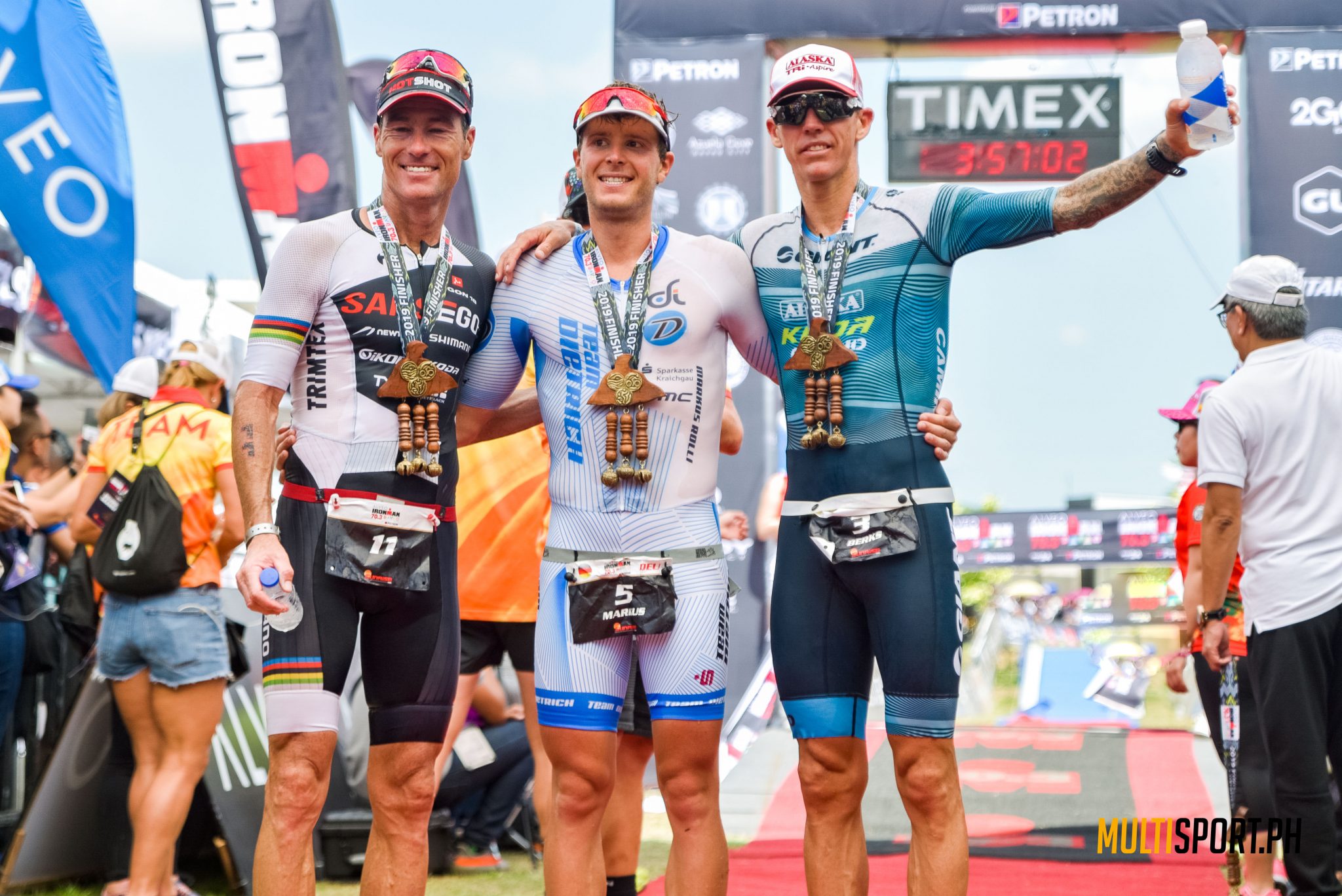 The top three finishers: Markus Rolli (center) is flanked by runner-up Craig Alexander (left) and third placer Tim Van Berkel